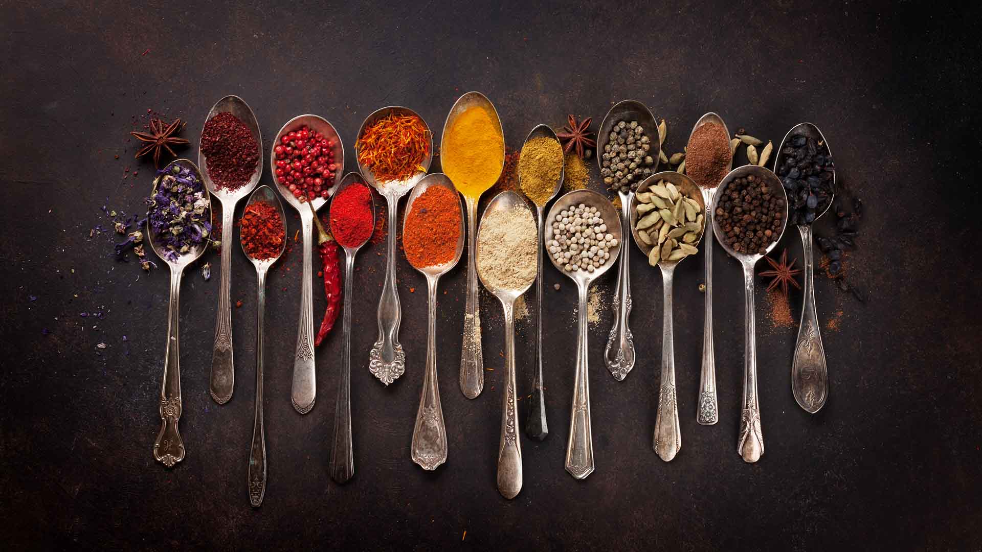 Various spices spoons on stone table. Top view