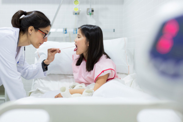 A doctor looking into a child's throat