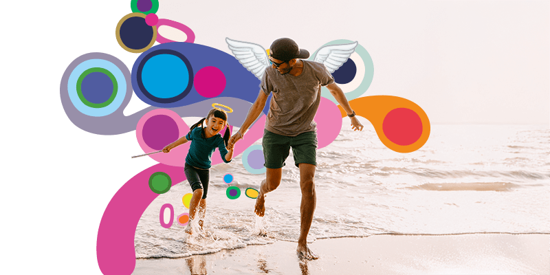 Father and daughter holding hands running on beach