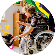 Woman in wheelchair playing with dog