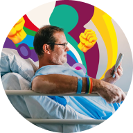 Man in hospital bed looking at phone