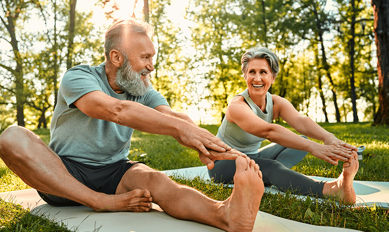 Older couple stretching during yoga
