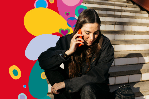 Young woman sitting on step using her phone