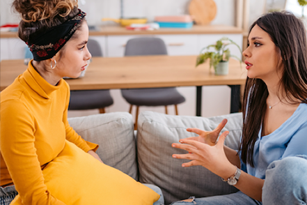two women talking on couch