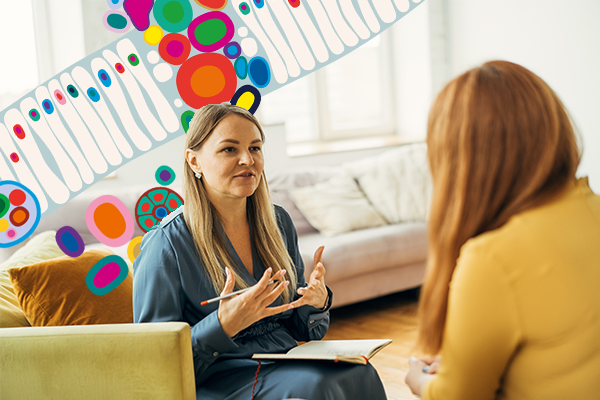 two women sitting on couch talking
