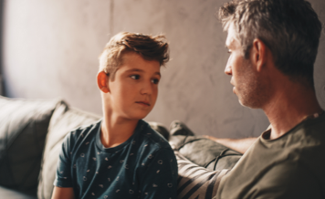 Boy sitting on couch with son