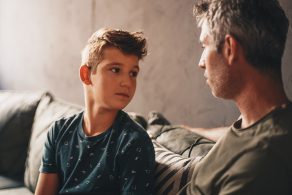 Father talking to son on couch