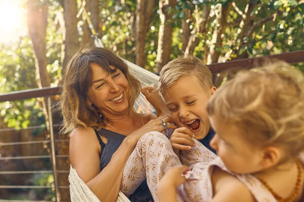 a mum holding a daughter while the dad carrying a box of flowers