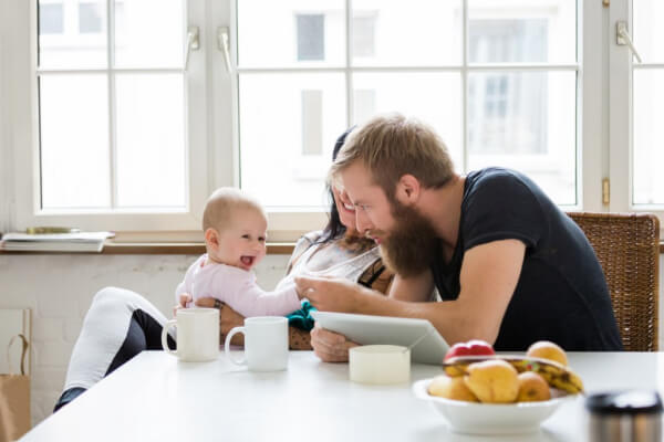 Young family sitting at the table with a happy baby