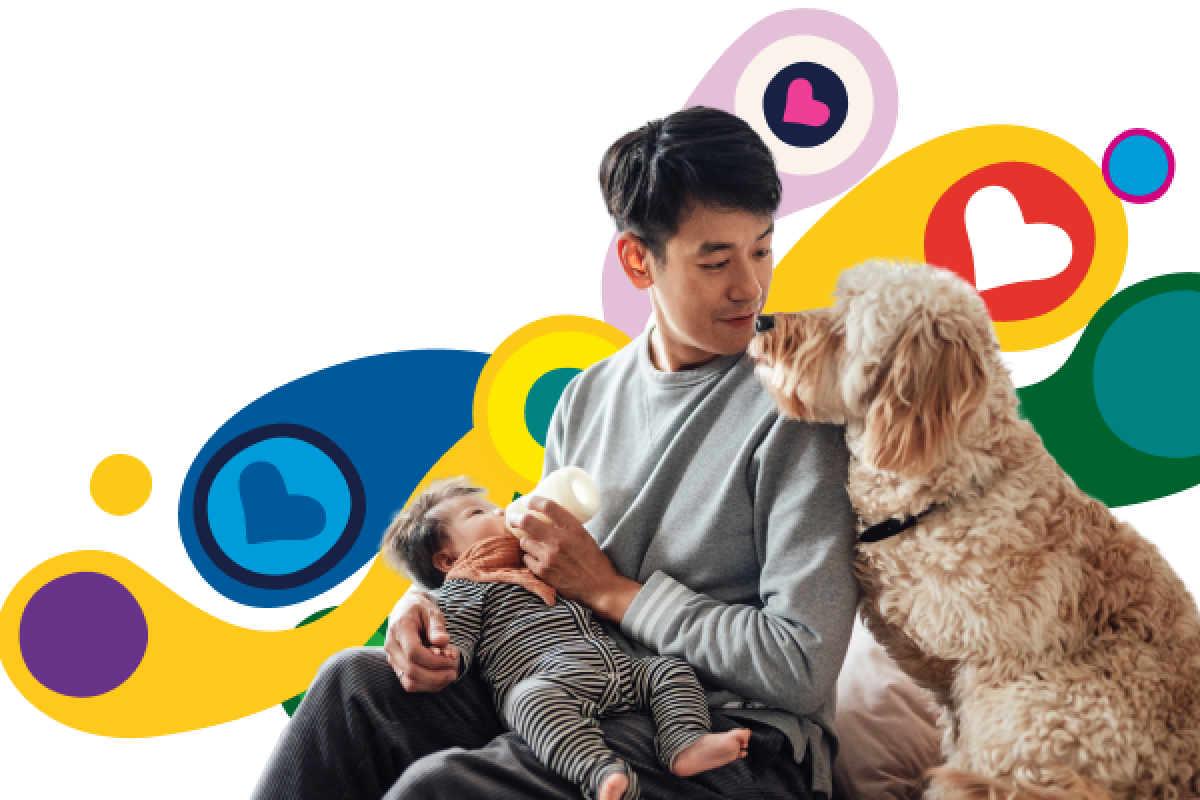 yound dad feeding baby accompanied by pet dog.