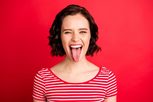 Closeup photo of fooling girlfriend, teasing you through camera while isolated with red background