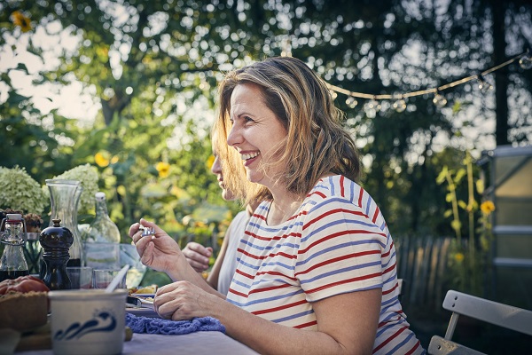 A woman eating a homemade meal at a picnic table as a way to reduce sugar intake.