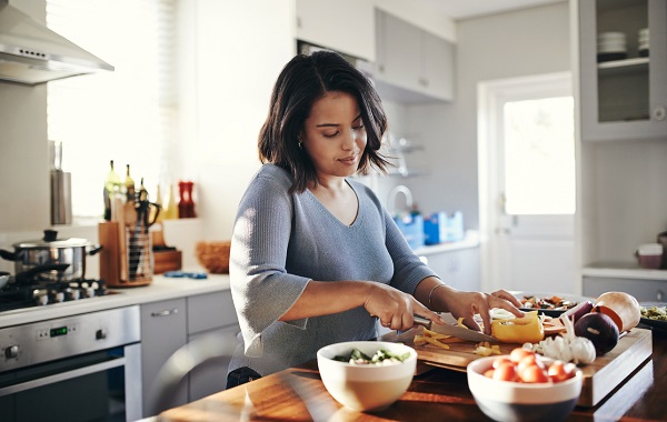 Shot of an attractive young woman cooking at home