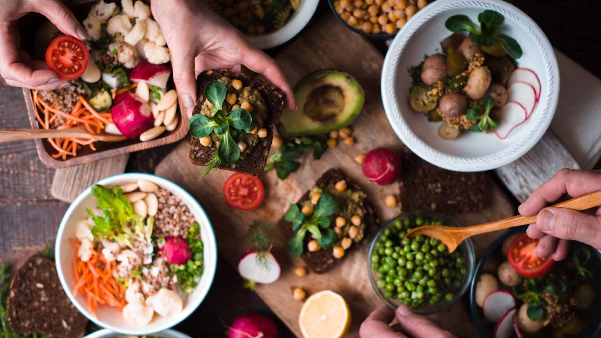 Eating different salad and appetizer on the wooden table top view