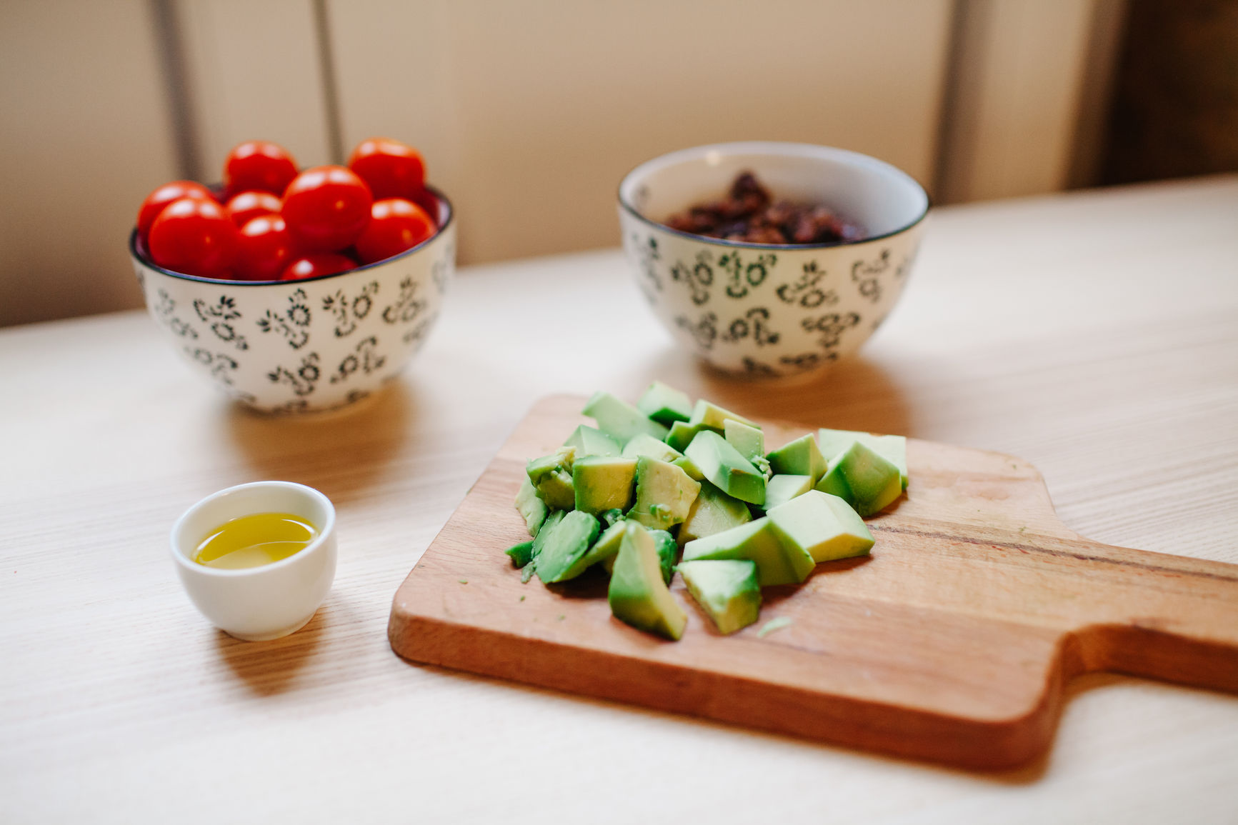 Table with avocado, tomatoes and another ingredients prepared for salad.