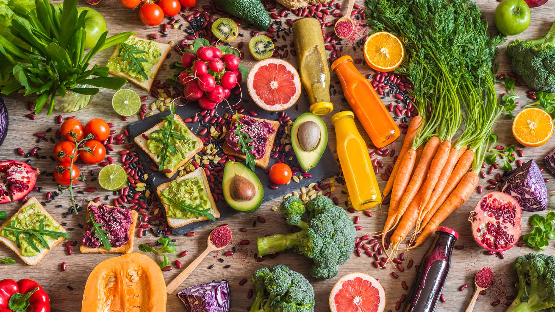Healthy vegan food. Fresh vegetables on wooden background. Detox diet. Different colorful fresh juices.