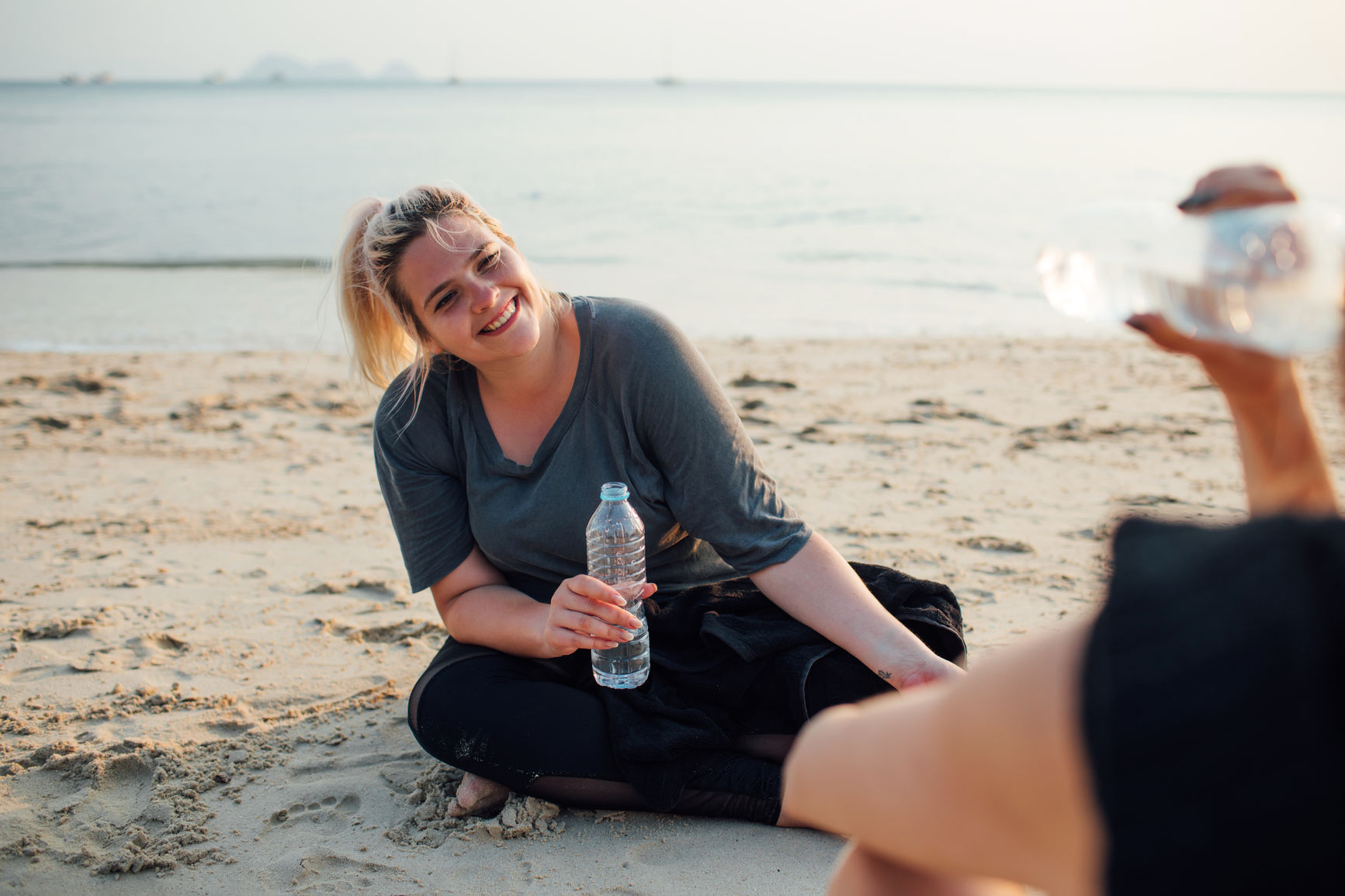 Two beautiful girls working out together on the beach