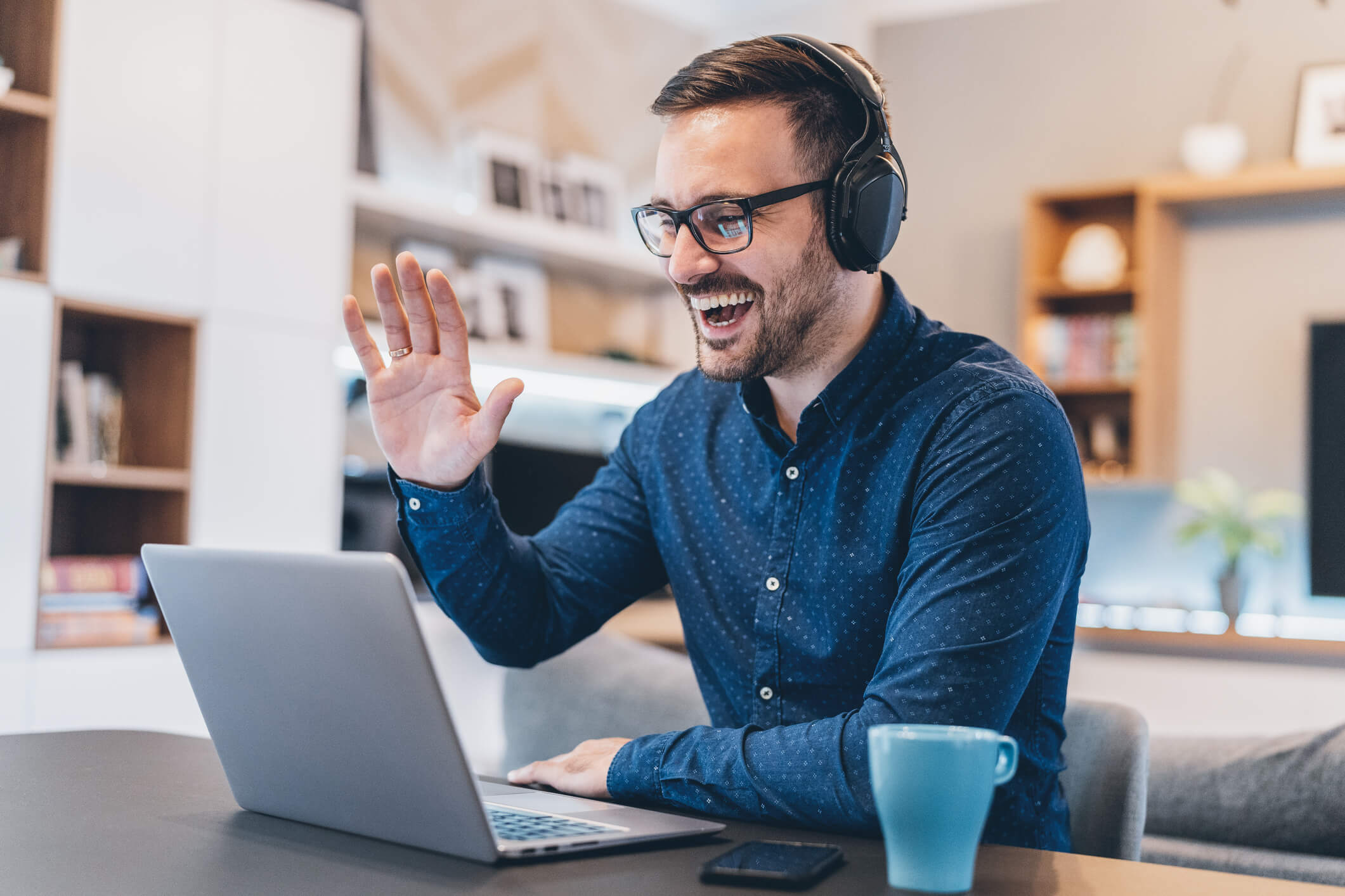 Man using his laptop to make a Skype call while working from home.