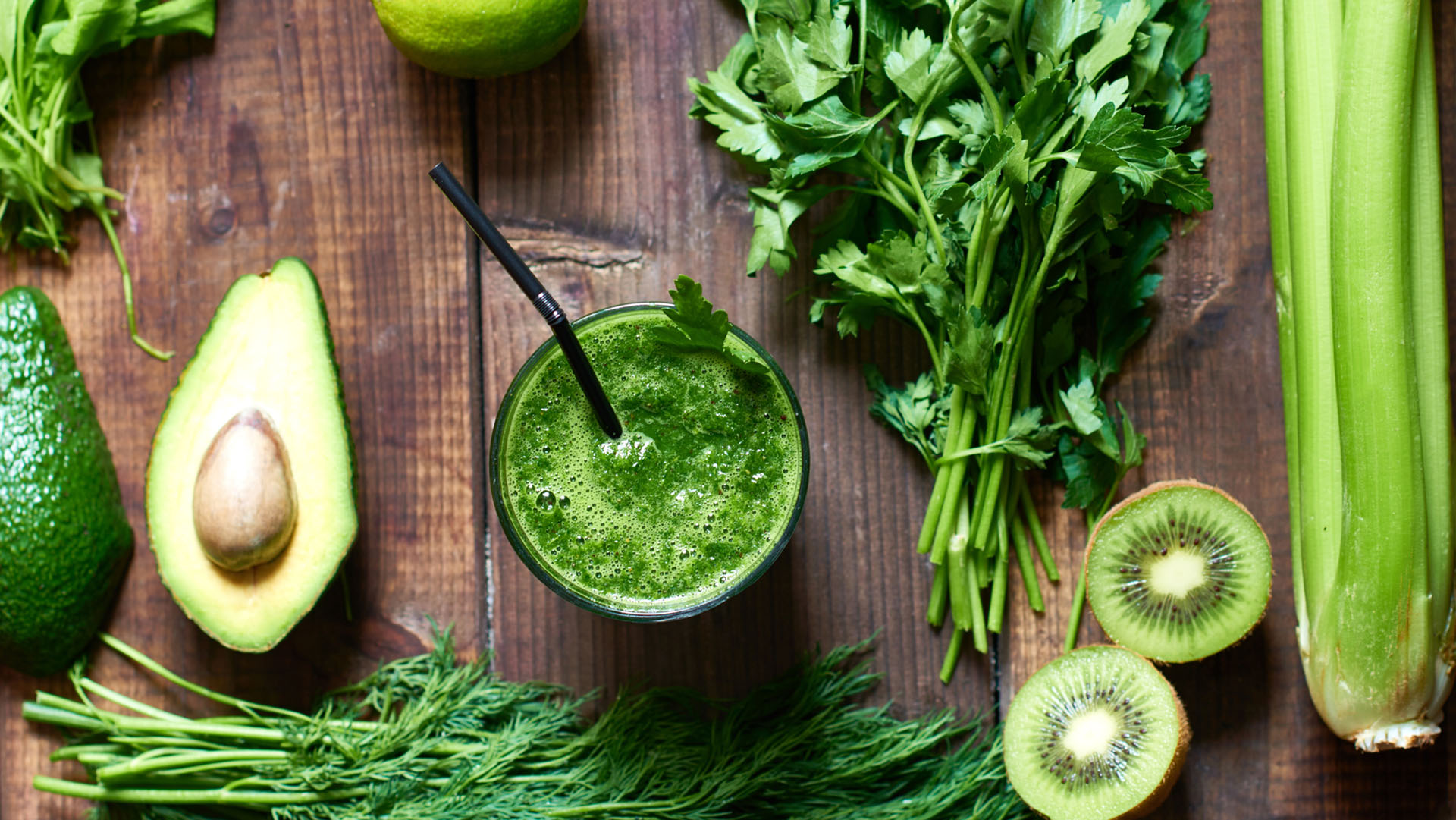 Fresh green smoothie surrounded with ingredients