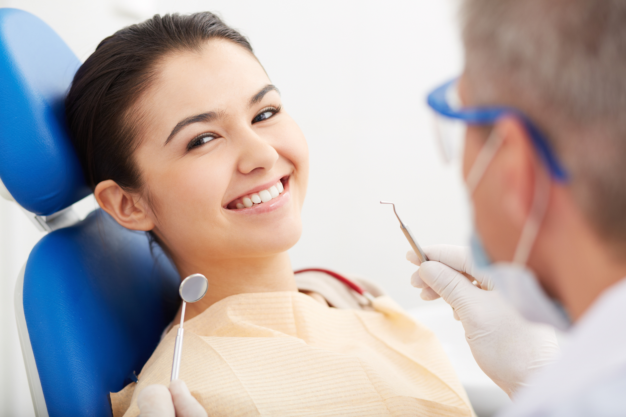 Image of smiling patient looking at camera at the dentist s