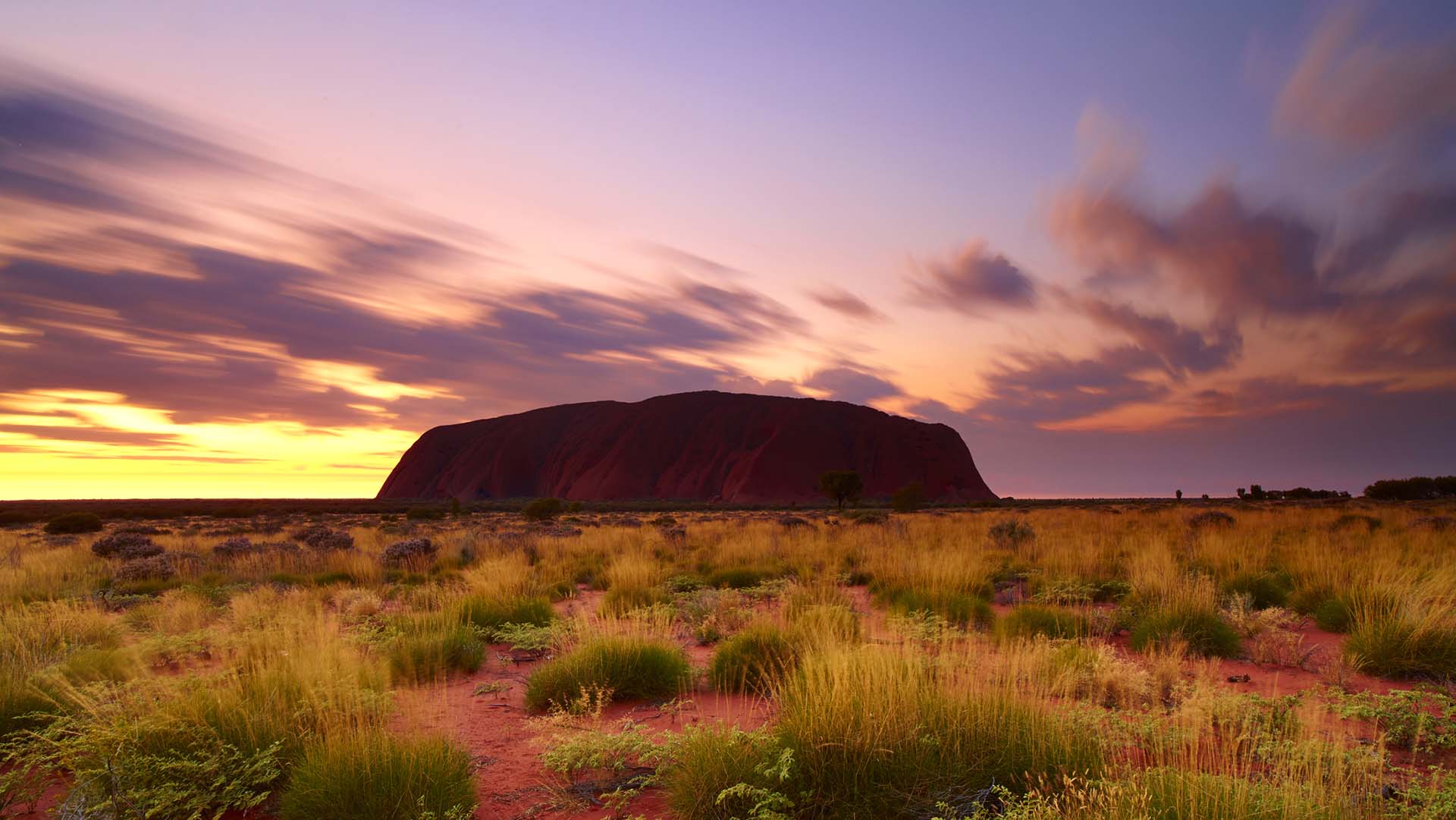 Northern Territory, Australia - May 18, 2011: Long exposure of dawn at Uluru, in Australia's Northern Territory. Sunrise is approaching, and the great sandstone monolith is lit by the lightening sky.