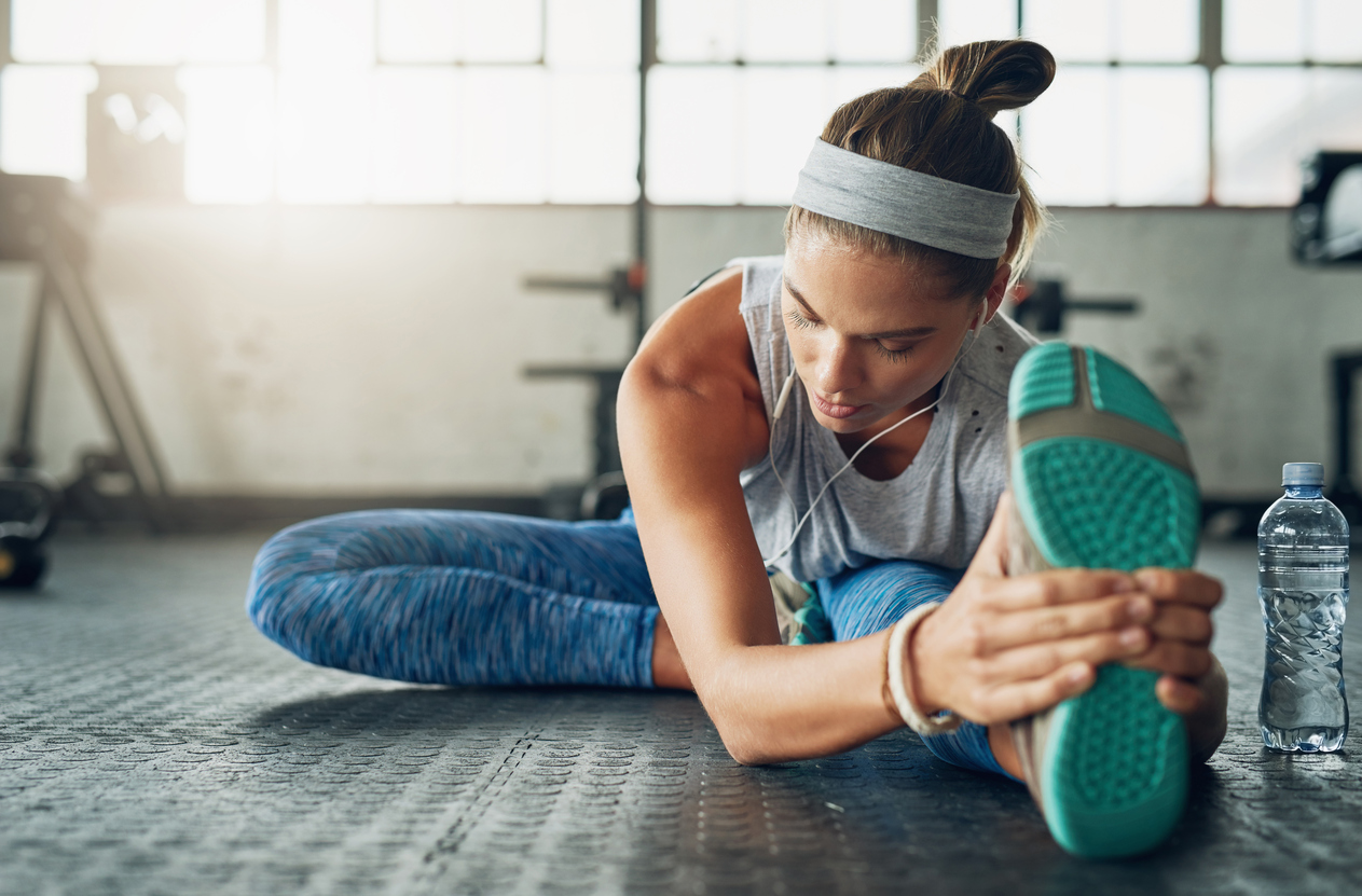 Shot of a young attractive woman stretching in a gym