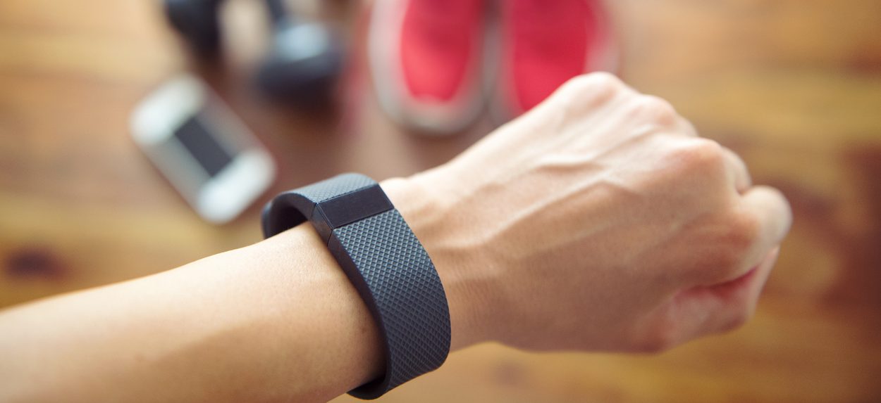 Berlin, Germany - July 11, 2016: Woman getting ready for her workout wearing a FITBIT as an activity tracker to control her heartrate.