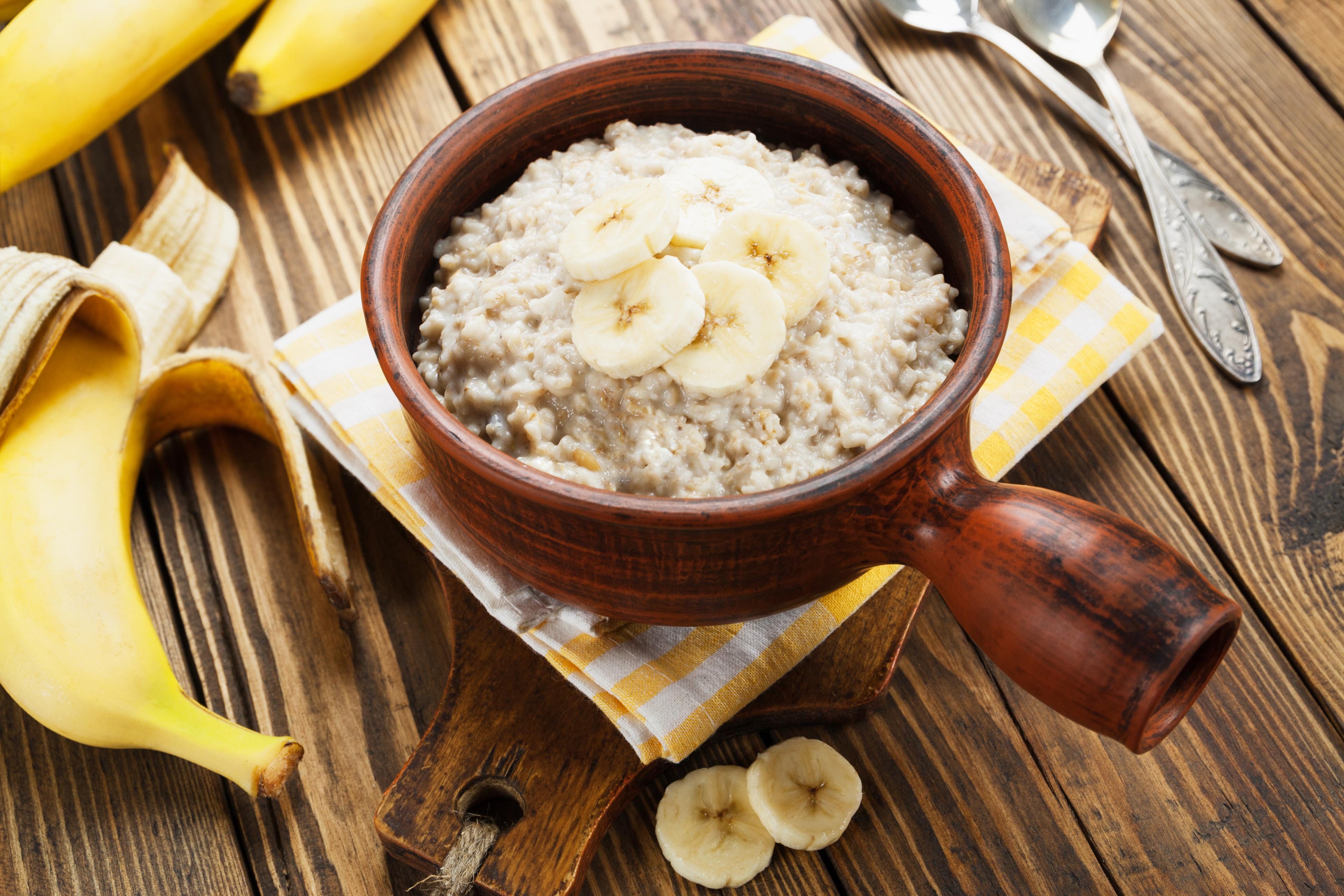 Porridge with bananas in the ceramic bowl on the table