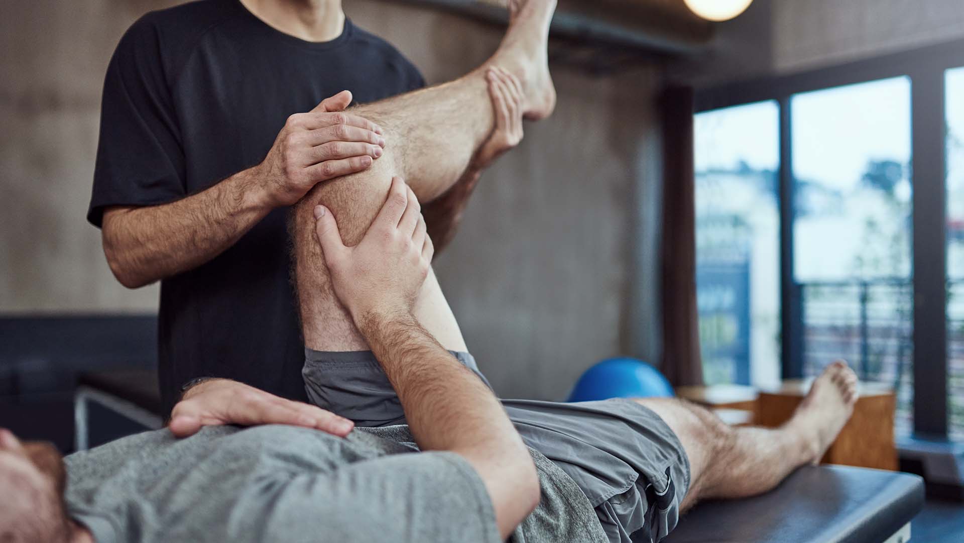 Shot of a young man visiting his physiotherapist for a rehabilitation session