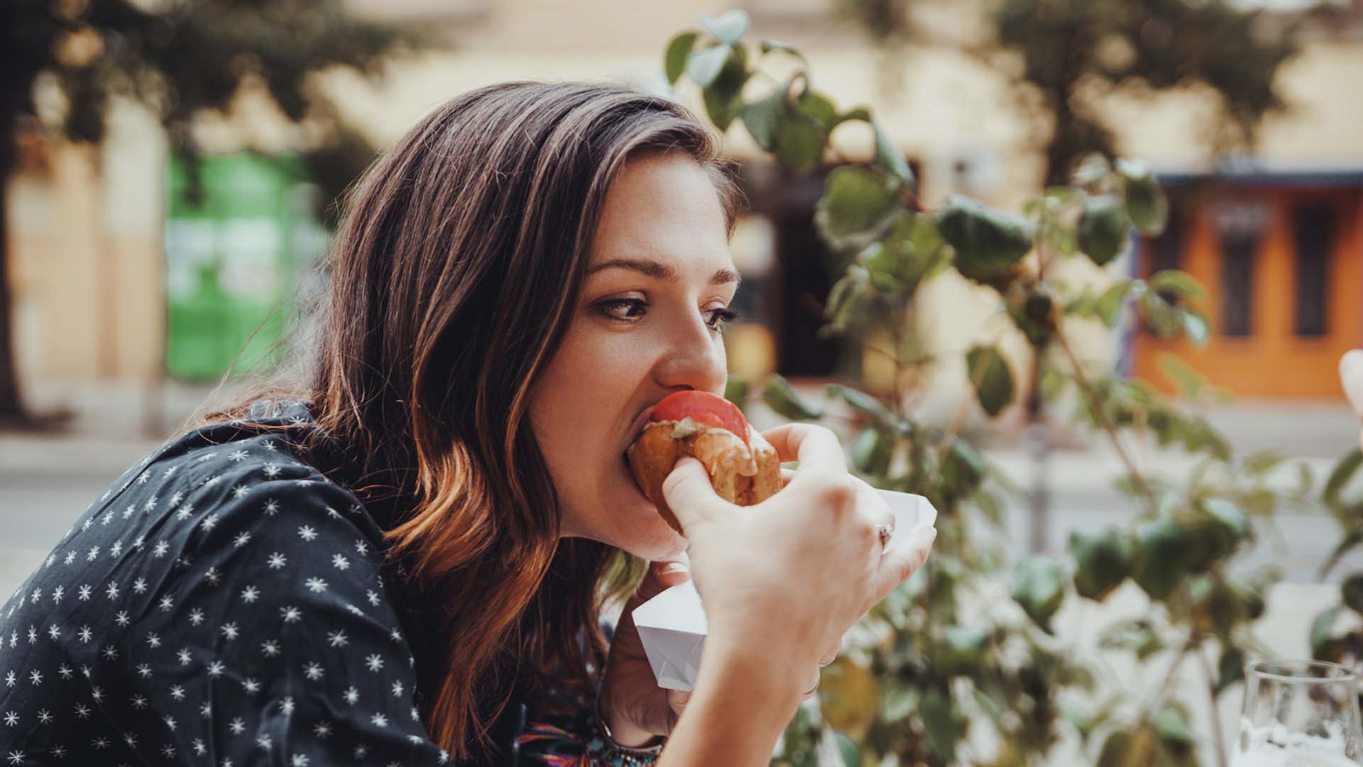 Young Woman Eating A Hotdog