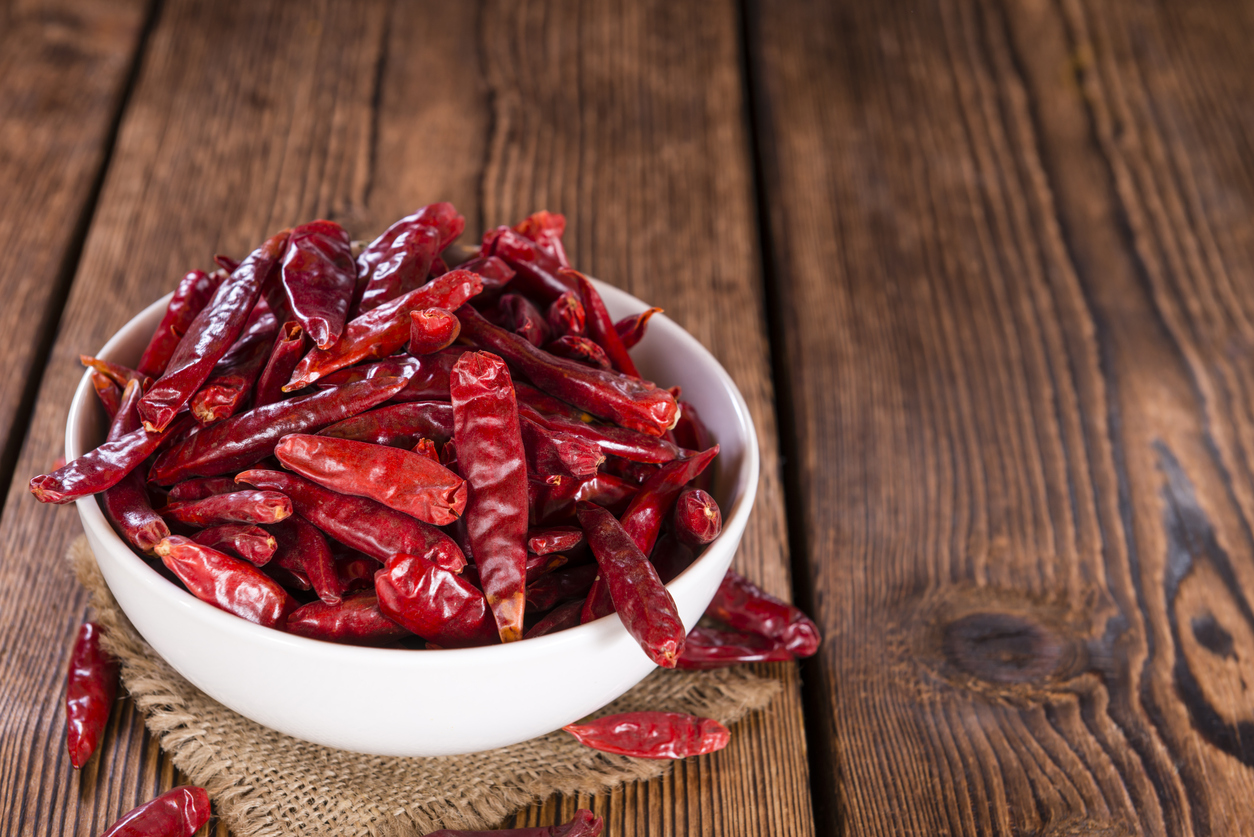 Portion of red Chillis (selective focus, close-up shot) on wooden background