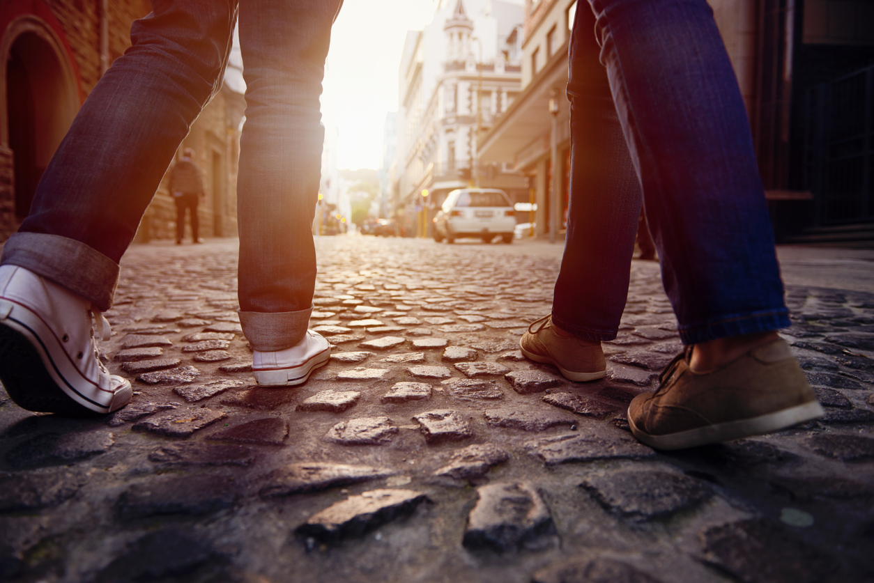 tourist couple walking on cobblestone street vacation in europe on holiday break