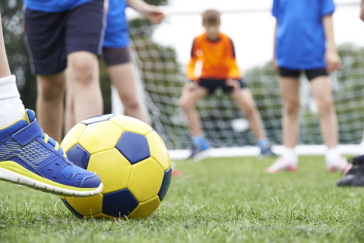 Close Up Of Children's Feet In Soccer Match