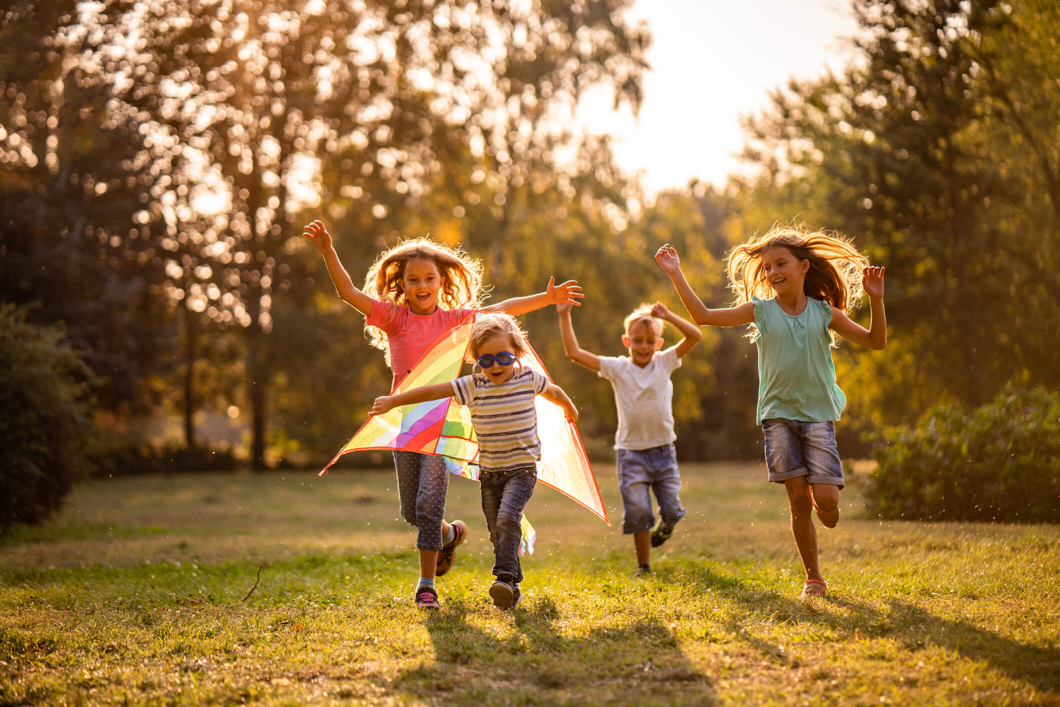 A group of four young kids playing together in a park.