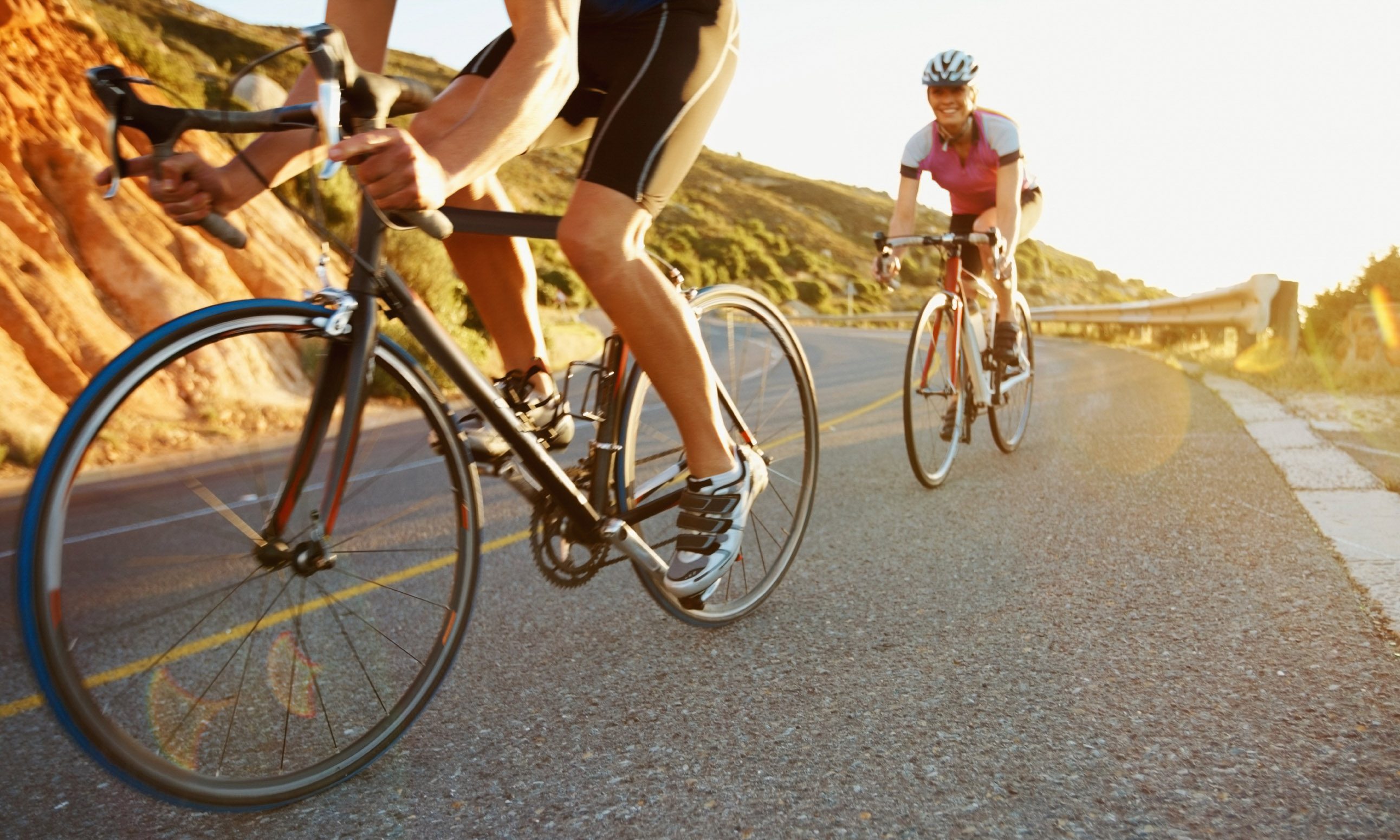 Man riding bicycle with woman trailing behind