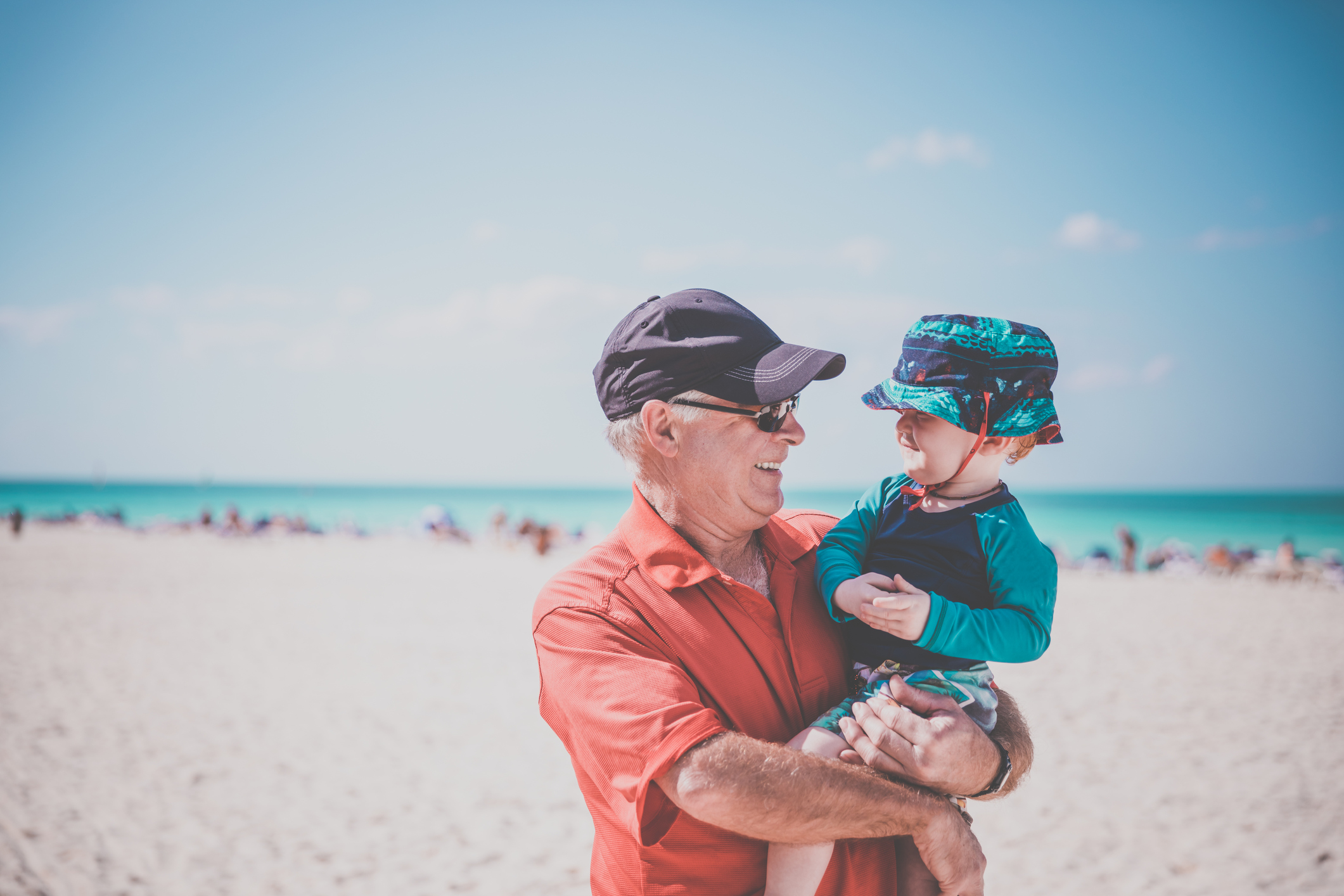 Grandfather Holding Baby Boy on Tropical Beach in Cayo Coco, Cuba