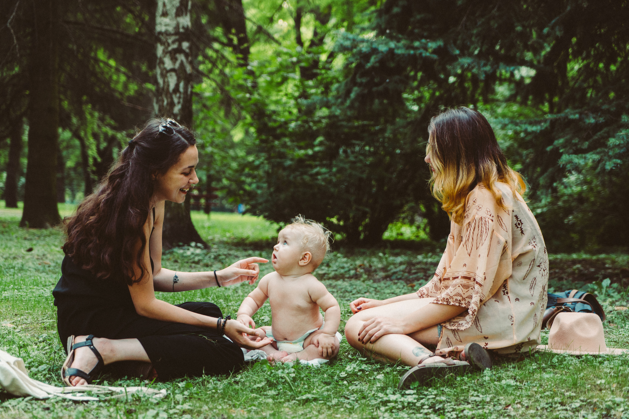 Two young Caucasian women playing  with baby