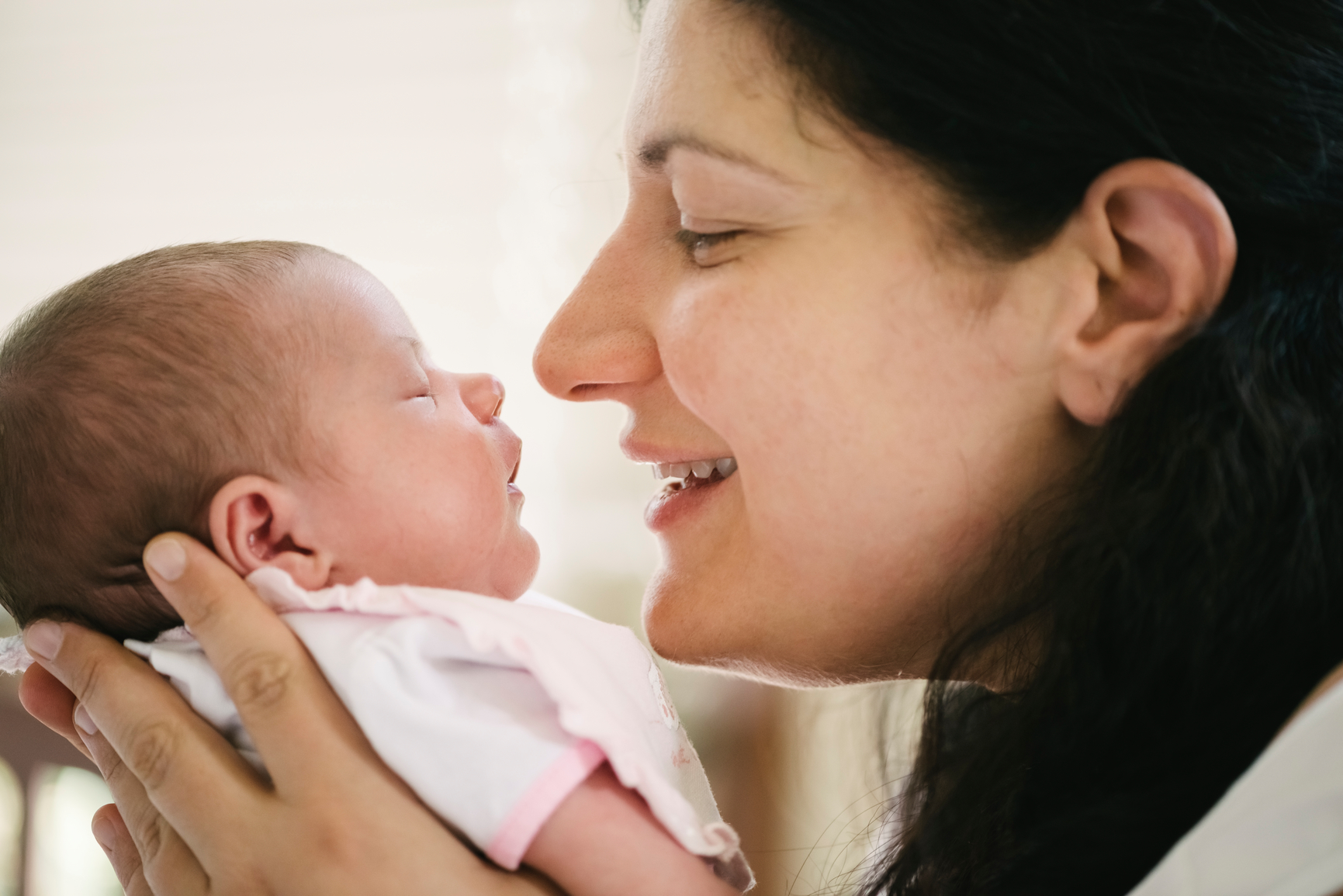 Mother holding her little baby face to face.