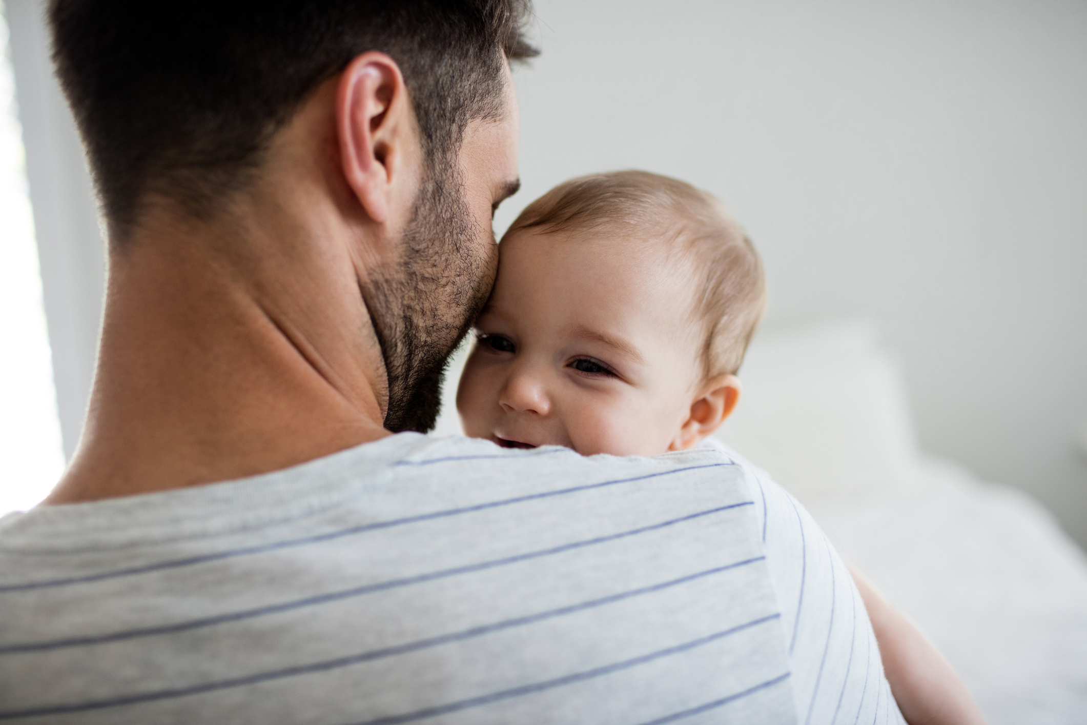 Father holding his baby girl at home