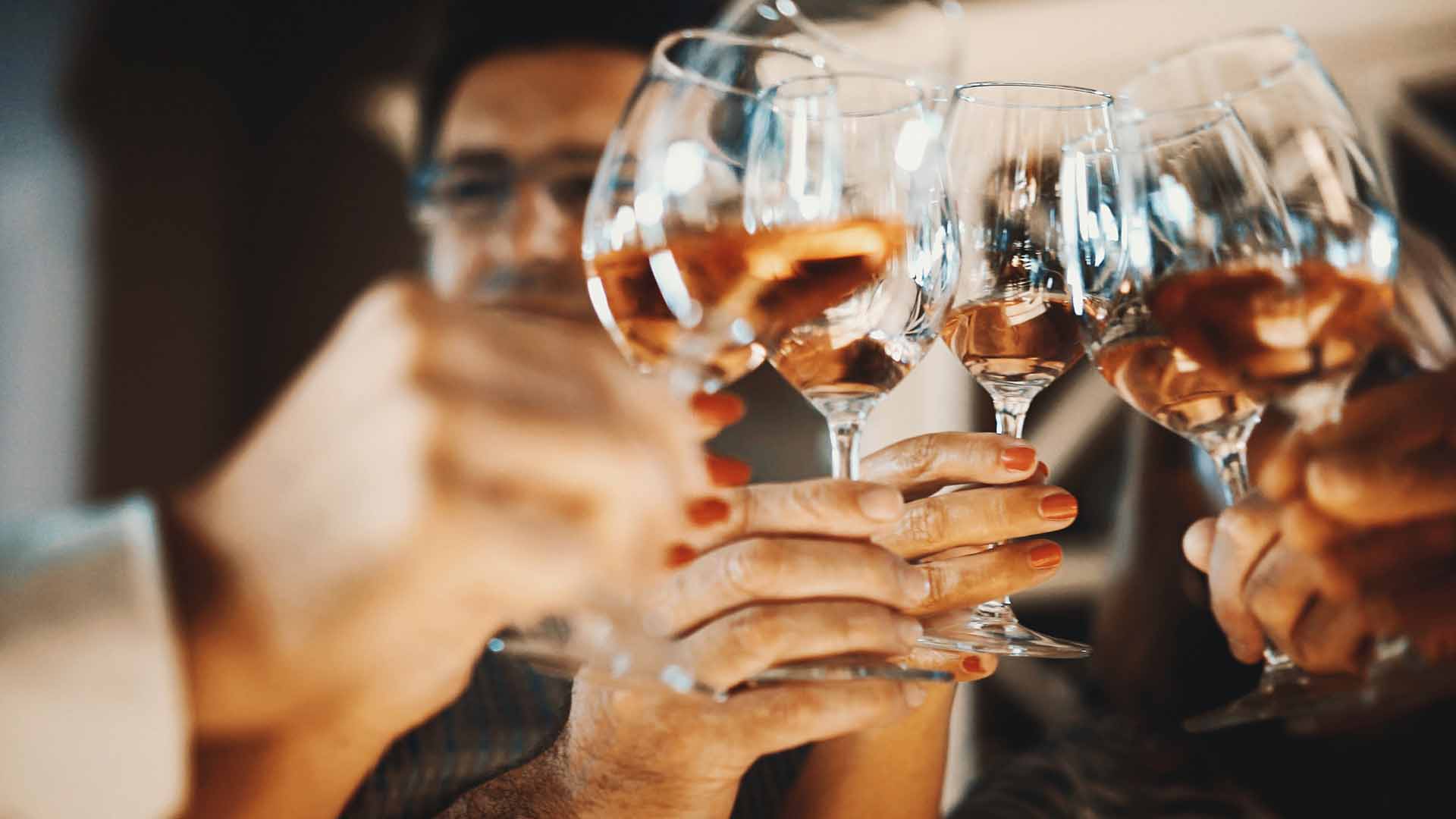 Closeup low angle view of group of unrecognizable people toasting with wine. This toast came after serious winetasting and scrutiny, uploaded soon.