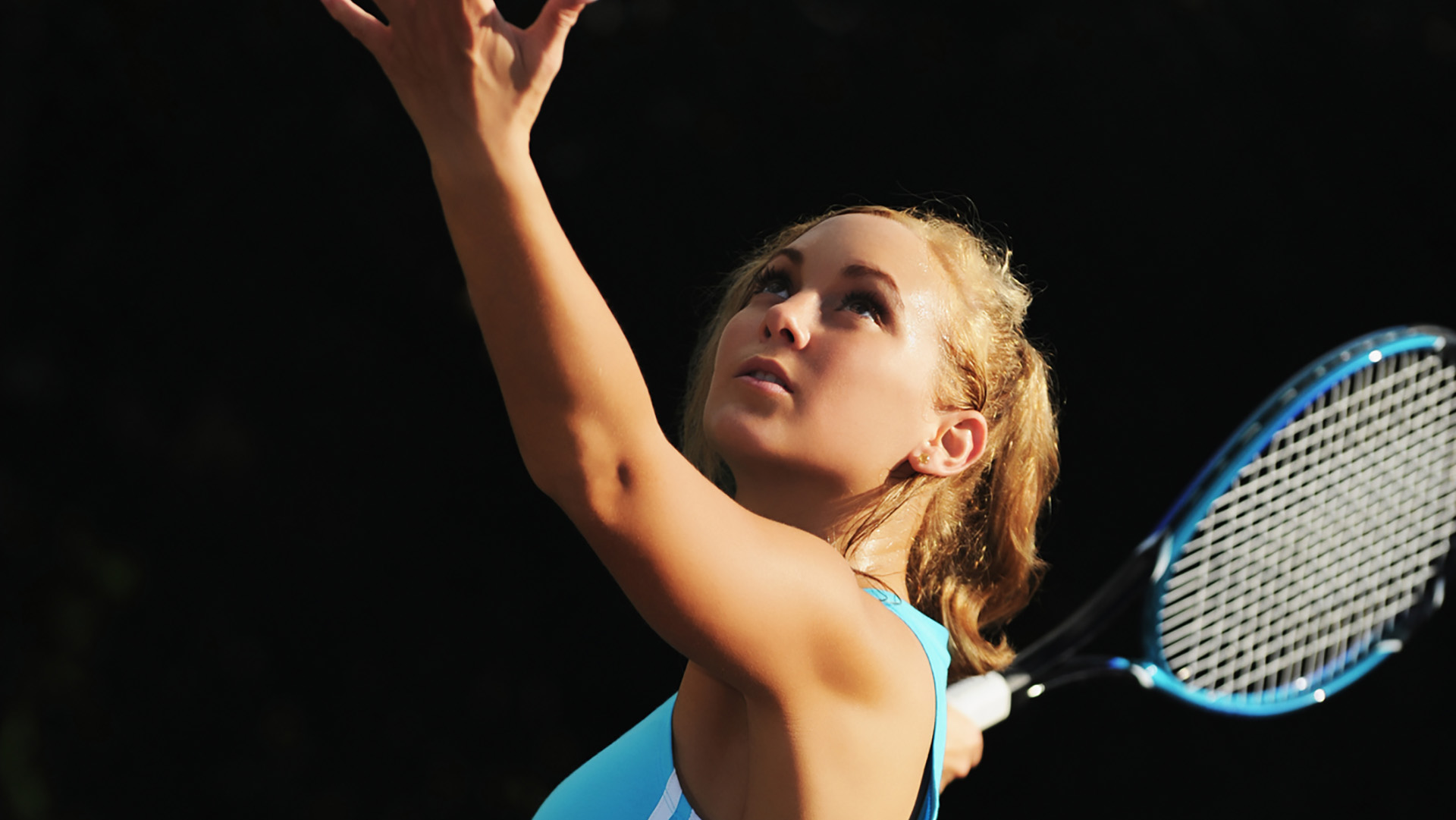 Young Blonde Woman Playing Tennis Serving