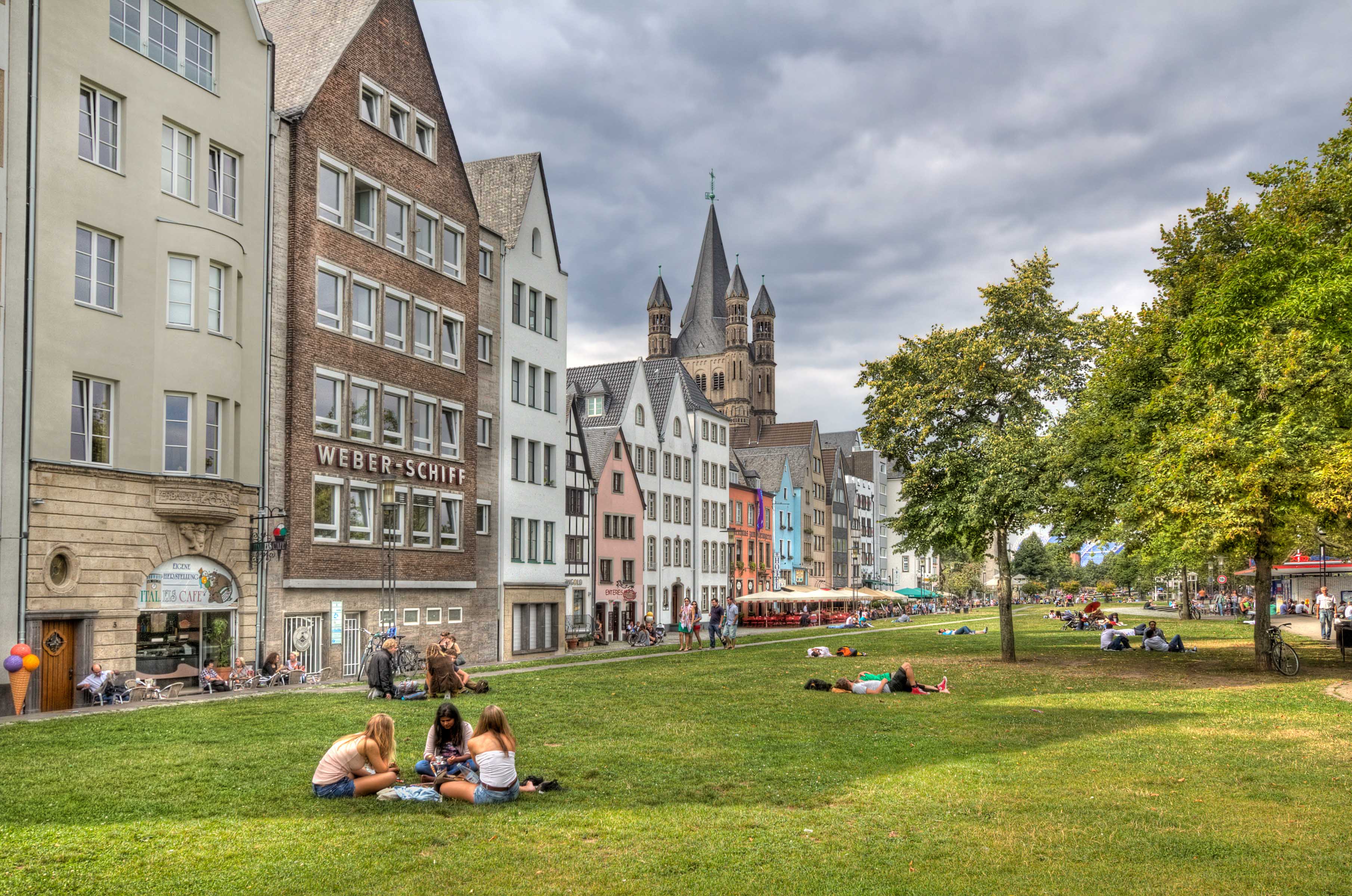 Cologne, Germany - August 27, 2013: People sitting on the grass at the riverfront in Cologne on August 27, 2013 in Cologne, Germany