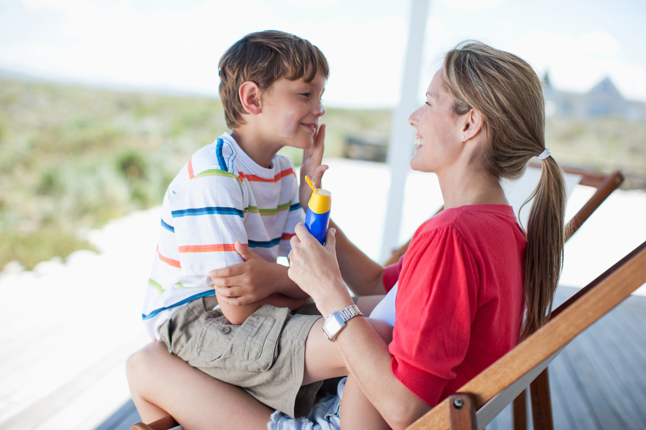 Mother putting sunscreen on boy