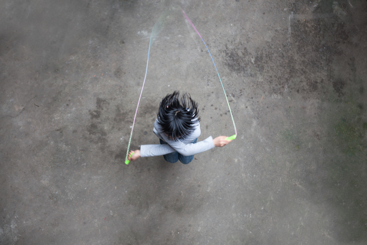asian girl playing rope skipping aerival view