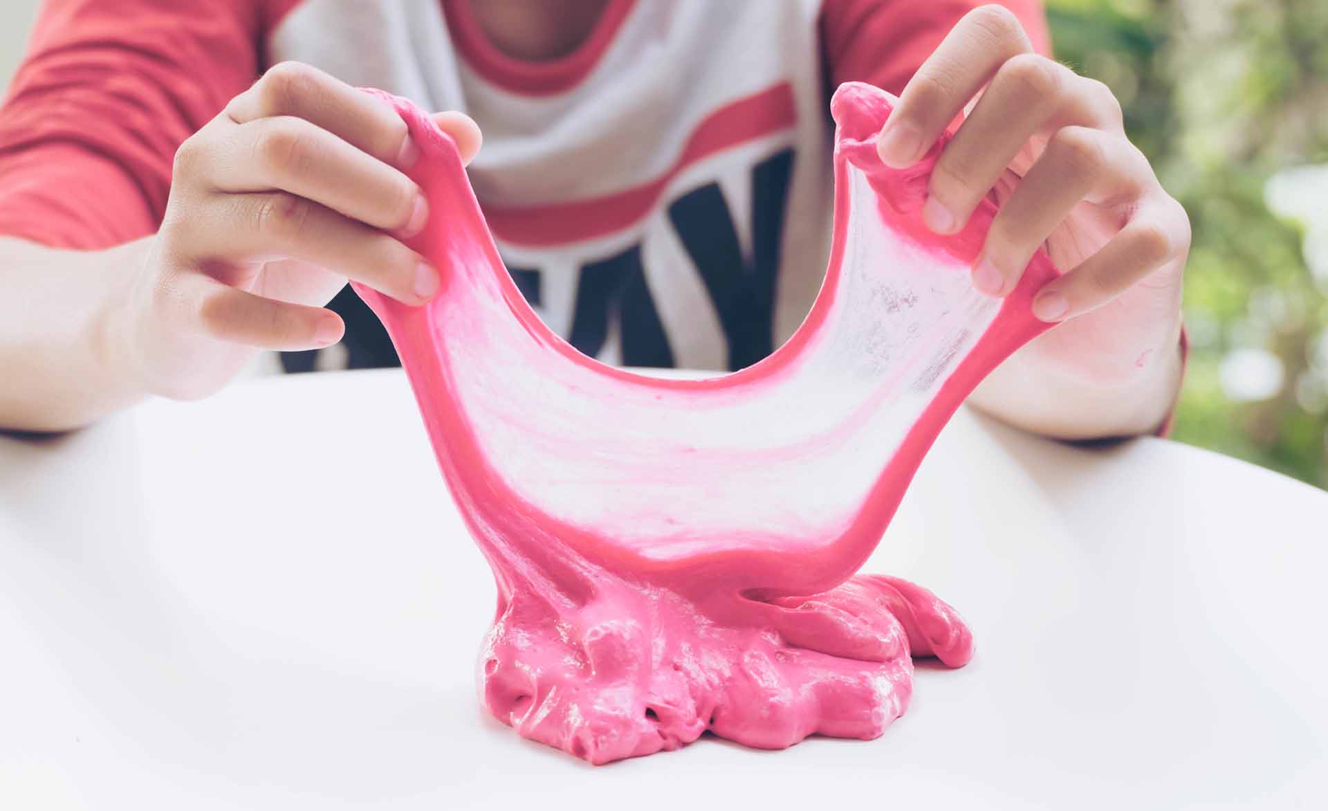 Hand Holding Homemade Plaything Called Slime, Teenager having fun and being creative homemade Toy, Selective focus on Slime.