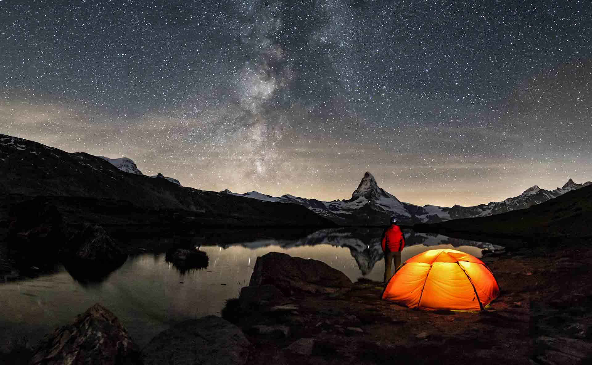 An illuminated tent under Milky Way at Matterhorn in Switzerland