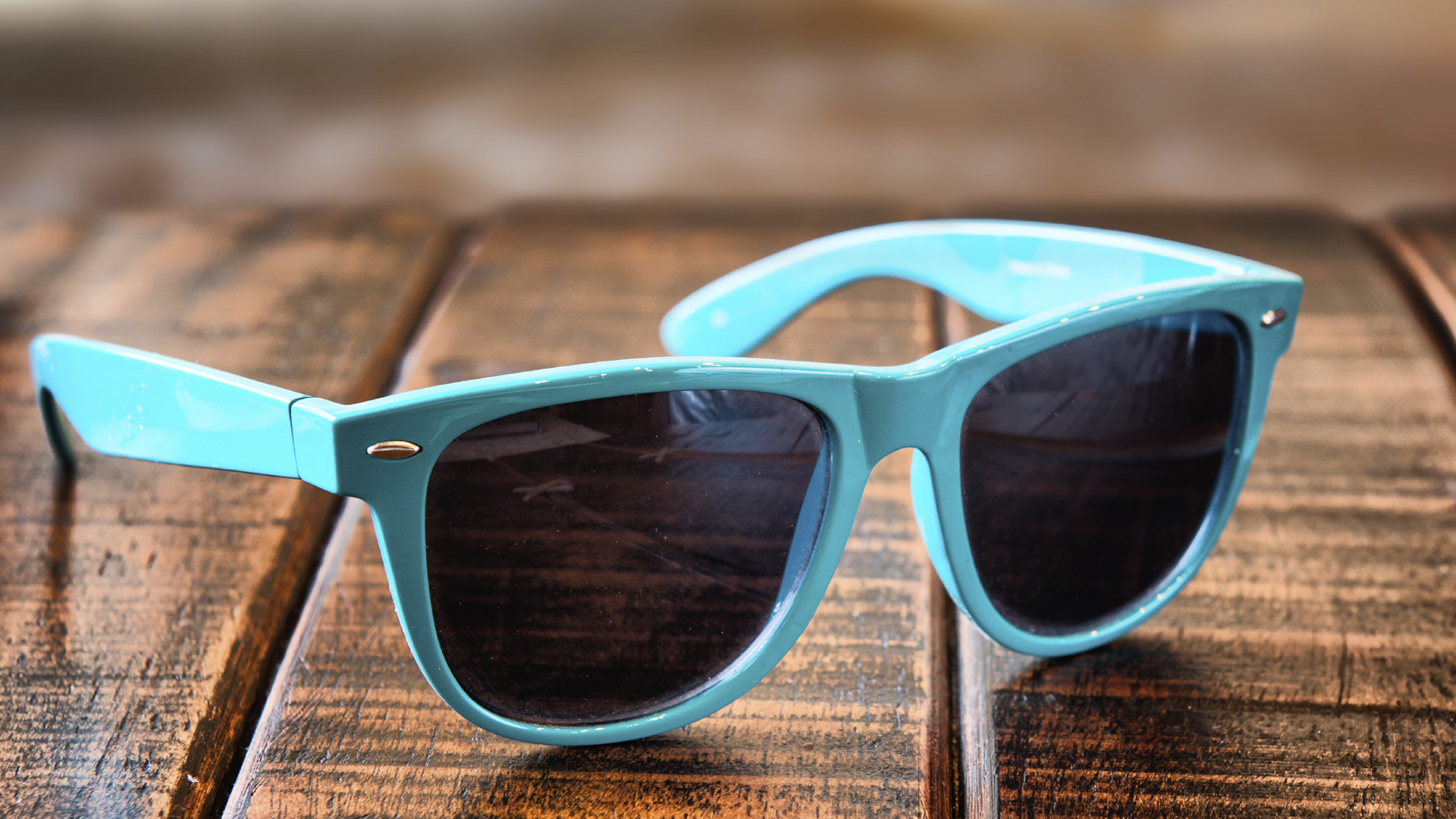 Sunglasses on wooden desk at the summer beach