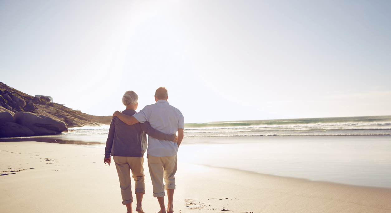 older couple walking along a beach