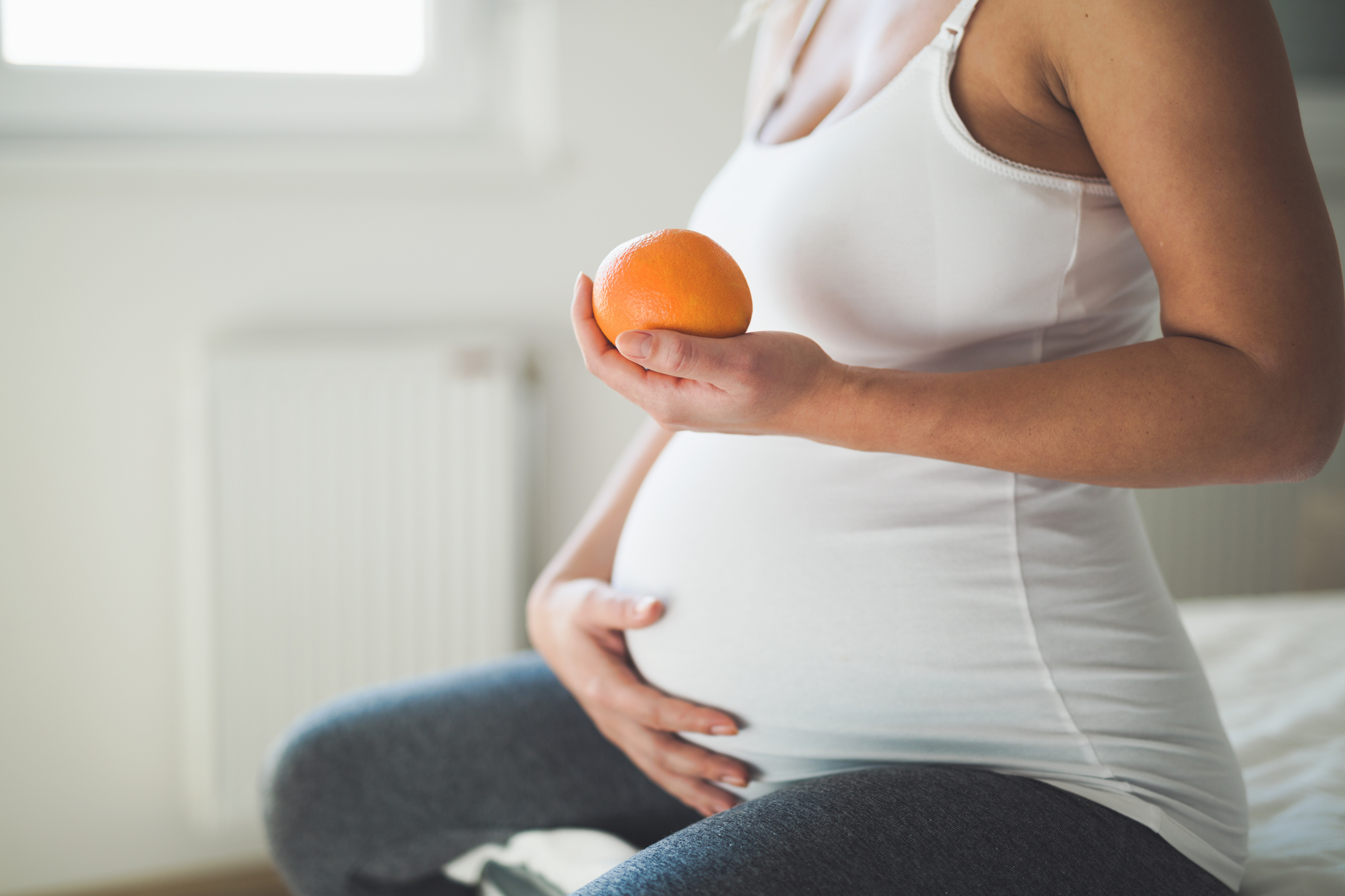 Pregnant woman having a healthy diet and eating fruit