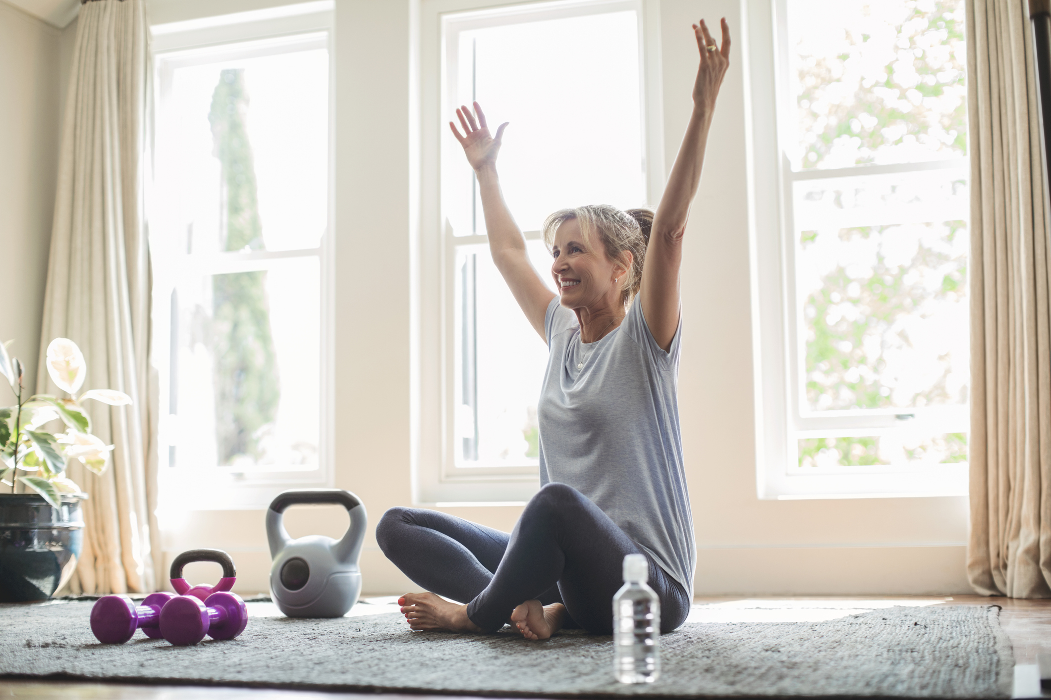 woman exercising sitting on floor with weights and dumbbell